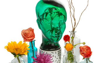 Green glass head and flowers in vases