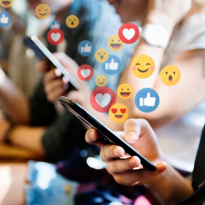 People on Mobile phones with social media lcons floating