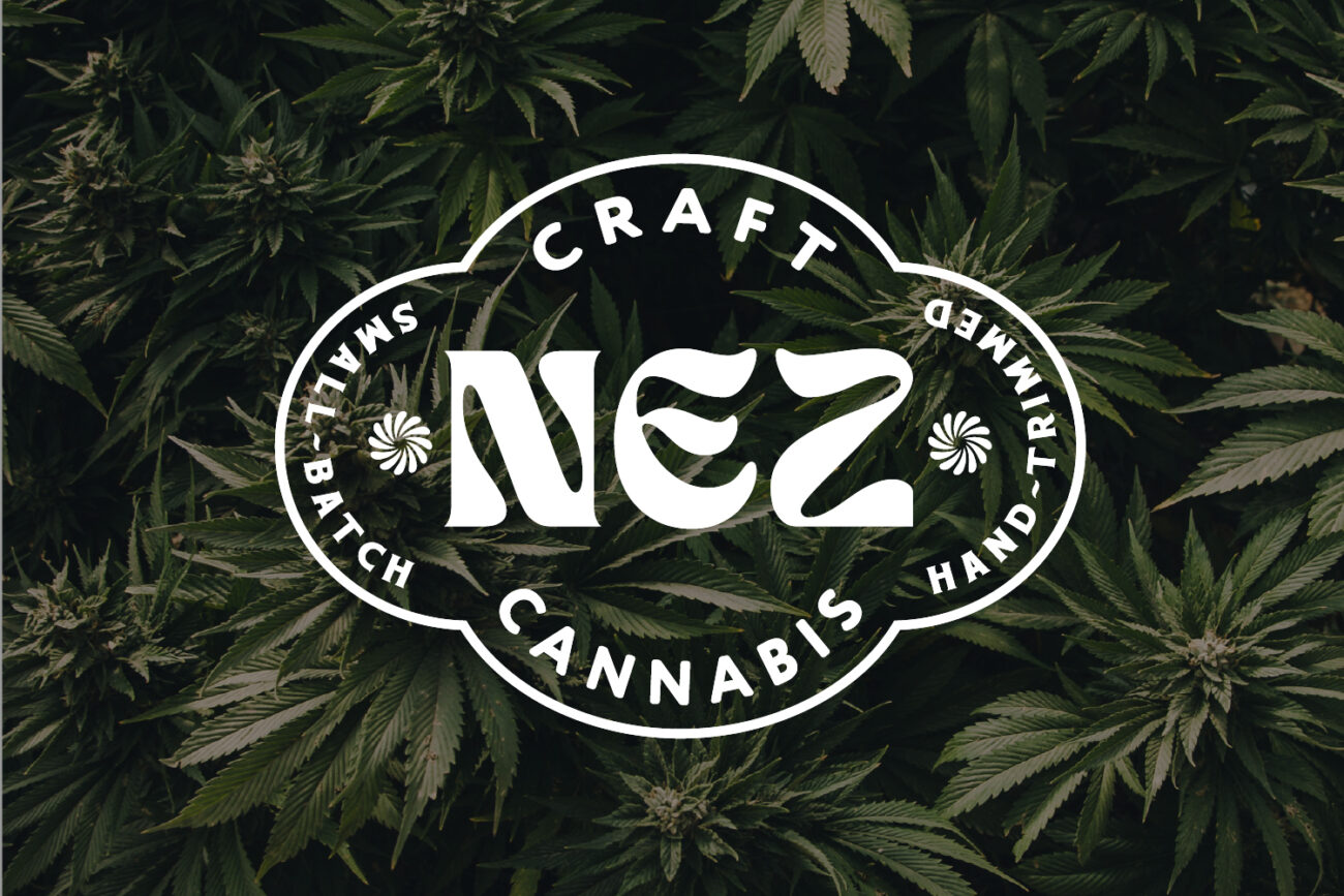 NEZ Craft Cannabis logo in white vintage-style typography over a background of dense cannabis plants, featuring text reading 'Small-Batch,' 'Hand-Trimmed,' and 'Craft Cannabis.'