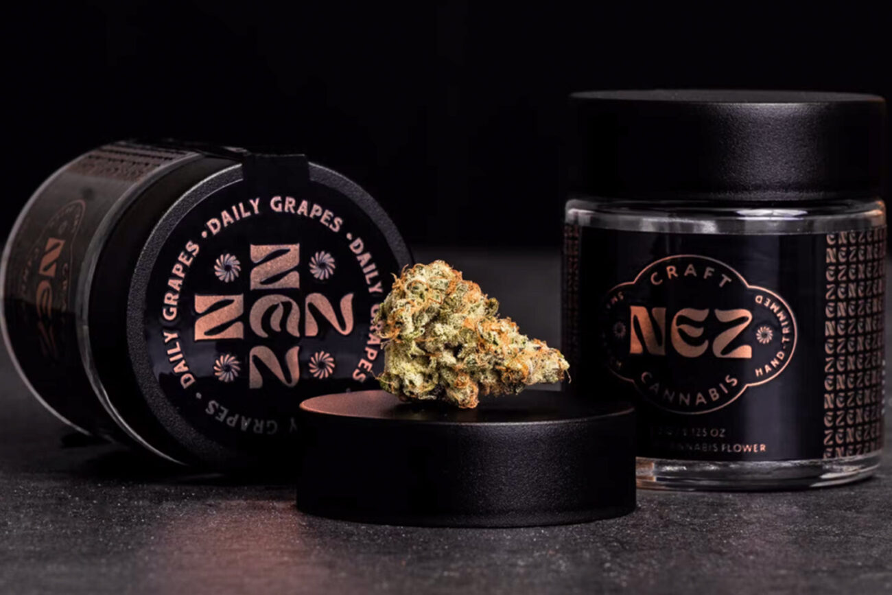 Luxury cannabis flower packaging for Nez, featuring black jars with copper foil branding and a premium bud displayed on a matte black lid.